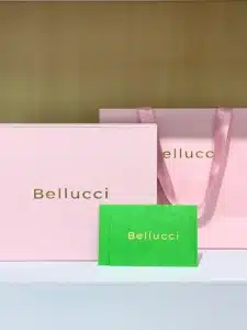 Complete Bellucci packaging set—pink gift box, matching bag and green thank‑you card with gold logo
