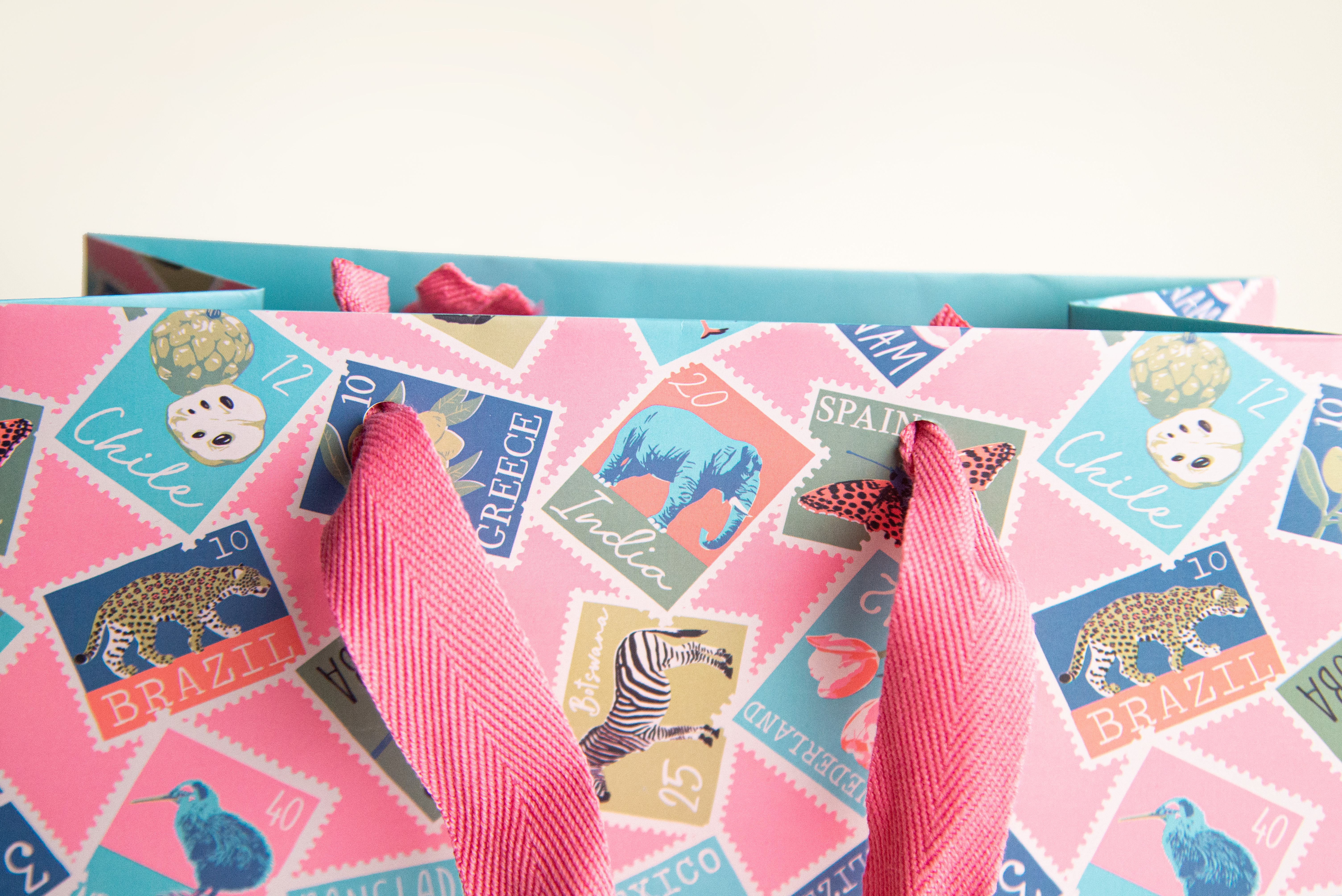 Full colour printed paper shopping bag with vibrant tropical stamp pattern in pink and multicolour