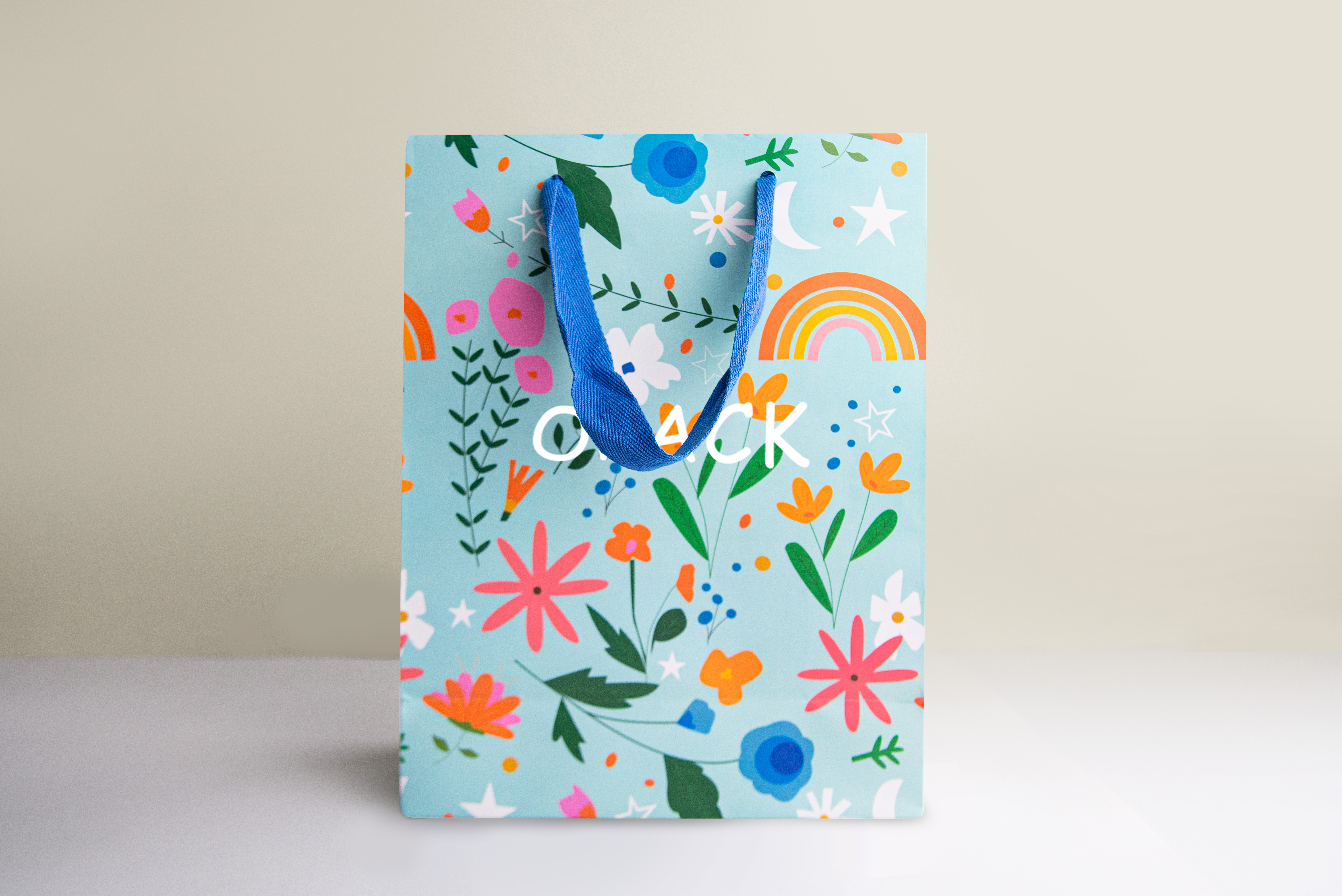 Light blue paper shopping bag with colourful floral and rainbow all-over print