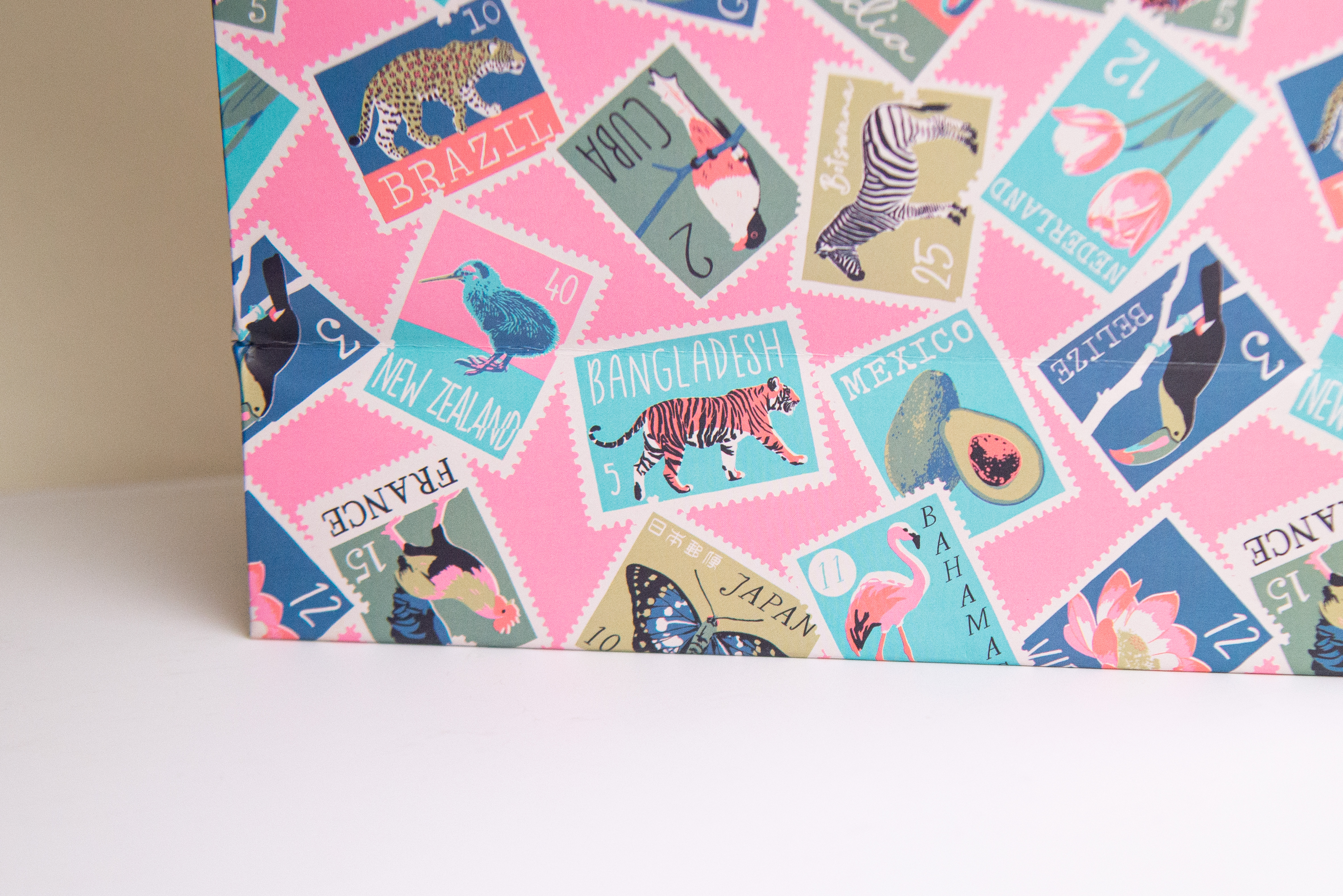 Pink paper shopping bag with colourful stamp and animal pattern print